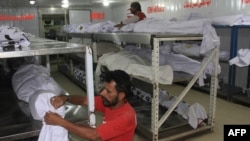 Pakistani volunteers adjust the dead bodies of heatwave victims at a morgue in Karachi late last month. 
