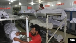 Пакистанські волонтери готують до поховання тіла жертв спеки в морзі в Карачі