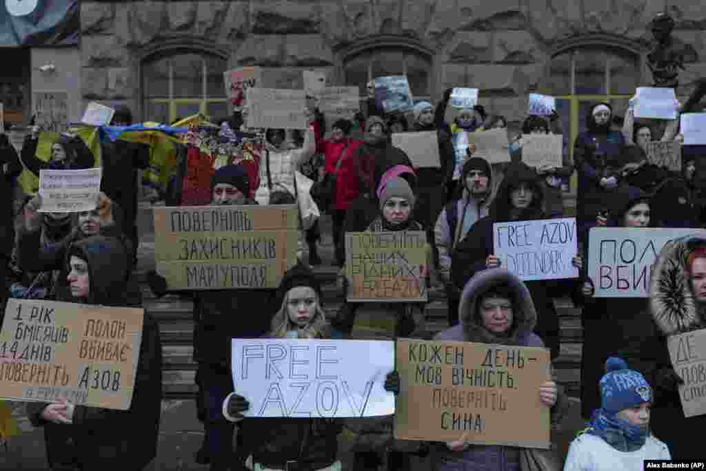 People hold posters during a demonstration against the Russian invasion in central Kyiv.