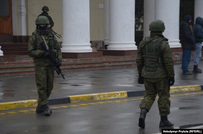 Озброєні люди у камуфляжі (як стало відомо згодом – російські військові) блокують Міжнародний аеропорт «Сімферополь», 28 лютого 2014 року Озброєні люди у камуфляжі (як стало відомо згодом – російські військові) блокують Міжнародний аеропорт «Сімферополь», 28 лютого 2014 року