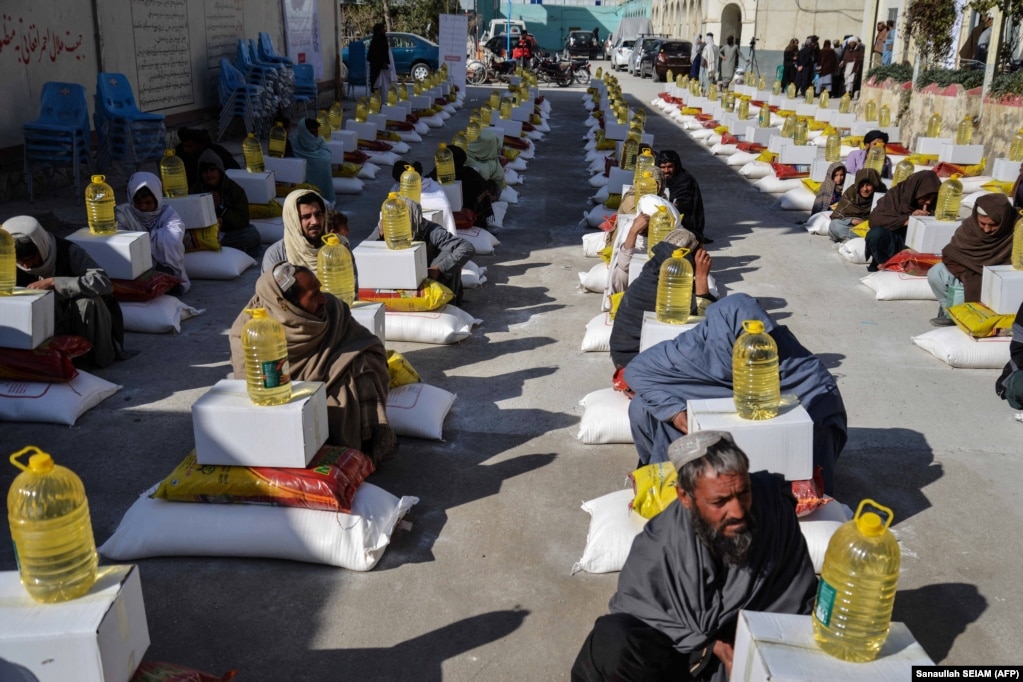 Afghan refugees deported from Pakistan receive food aid from the Red Cross Society in Kandahar on January 24.