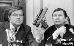 Франк Чърч, председател на комисията по разузнаване в Сената на САЩ, показва пистолет, който изстрелва отрова, 17 септември 1975 г.