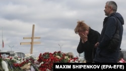 A woman weeps at an impromptu memorial to the victims of a shooting attack at a concert venue near Moscow. 