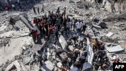 Sérültek után kutatnak egy izraeli légicsapásban összedőlt épület romjai között a Gázai övezet déli részén található rafahi menekülttáborban 2024. március 20-án
