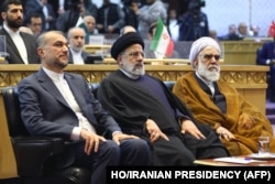 Iranian Foreign Minister Hossein Amir-Abdollahian (left) sits next to President Ebrahim Raisi (center) at a conference in Tehran in December 2023.