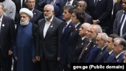 ფოტოზე: ირაკლი კობახიძე ირანის პრეზიდენტის ინაუგურაციაზე, ჰამასის პოლიტიკური ლიდერის, ისმაილ ჰანიეს გვერდით (მათ შორის ერთი ადამიანი დგას). ჰანიე ამ ფოტოს გადაღებიდან მეორე დღეს მოკლეს.