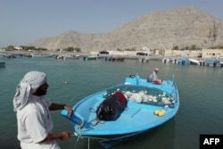 Pescarii omaniți își trag barca într-un mic port din zona Khasab din Oman, de-a lungul strâmtorii Ormuz din Golf
