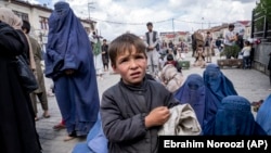 A woman and boy beg for alms outside a mosque during Ramadan in Kabul. (file photo)