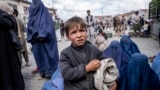 An Afghan boy and women beg outside a mosque in Kabul.