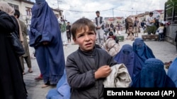 An Afghan boy and women beg outside a mosque in Kabul.