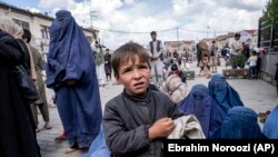 Një djalë dhe disa gra duke kërkuar lëmoshë jashtë një xhamie gjatë Ramazanit në Kabul - Fotografi nga arkivi.