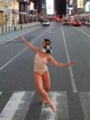 Балерина Эшли Монтегю  танцует в противогазе на Таймс-сквер в центре Нью-Йорка во время вспышки COVID-19, 18 марта 2020 года