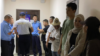 Members of the so-called Kempir-Abad Defense Committee await trial at a Bishkek court on June 22.