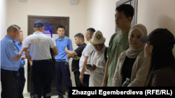 Members of the so-called Kempir-Abad Defense Committee await trial at a Bishkek court on June 22.