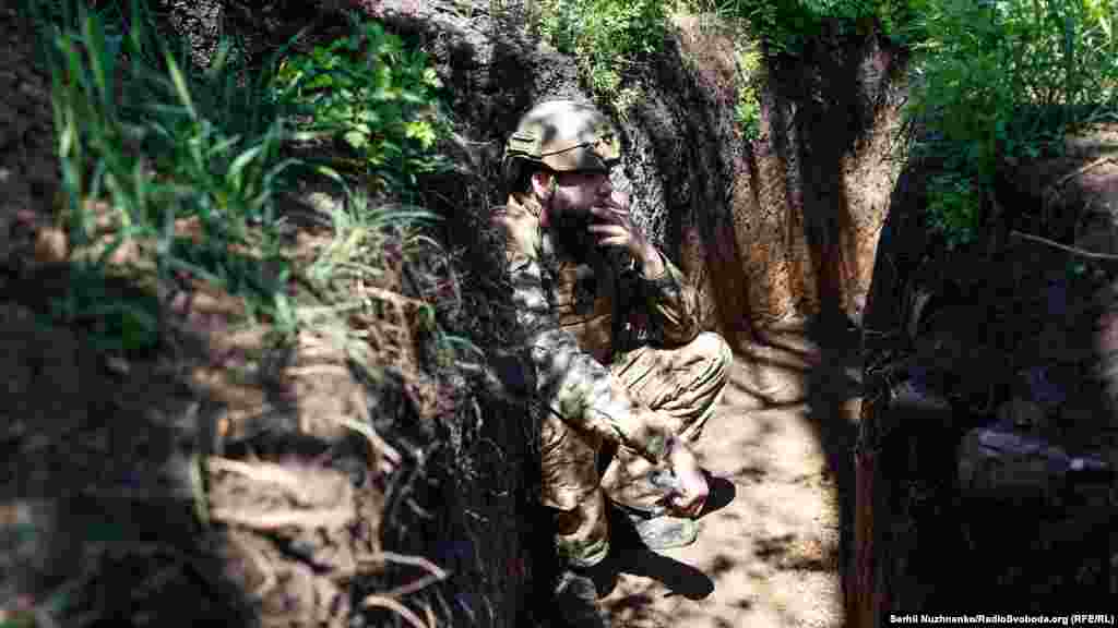 Un soldat al Brigăzii 68 Independent Jager fumând în tranșee în timpul luptelor de pe linia frontului din sudul regiunii Donețk, pe 5 mai.