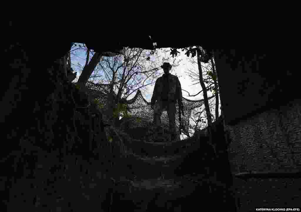 A Ukrainian soldier inspects a former Russian position outside the village of Robotyne near the front line in the Zaporizhzhya region of southern Ukraine on November 4. Russia and&nbsp;Ukraine&nbsp;gave contradictory&nbsp;accounts over the weekend&nbsp; of November 4-5 about what is occurring along the front line in the Zaporizhzhya region, with Moscow saying it has stopped Kyiv&#39;s counteroffensive while Ukraine&#39;s military claims it is continuing with its attacks.