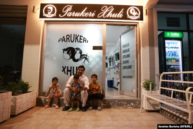 Abdulrrahman Safe me fëmijët e tij para sallonit të flokëve “Xhuli” në Shëngjin të Shqipërisë.
