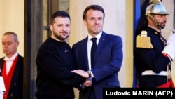 Президентът на Украйна Володимир Зеленски (вляво) е посрещнат от президента на Франция Еманюел Макрон при пристигането си в президентския дворец Елисей в Париж на 14 май 2023 г.