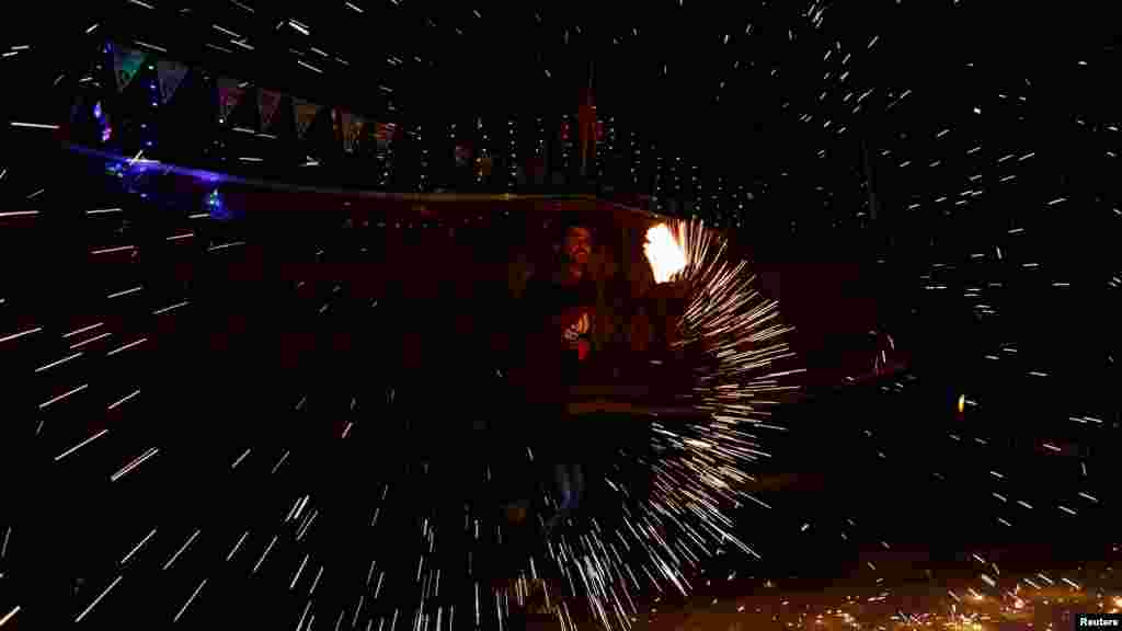 Egy férfi házi készítésű szikracsöves tűzijátékot pörget Rafahban 2024. március 9-én. A ramadán kezdetét az iszlám holdnaptár határozza meg. A palesztinok számára hétfőn kezdődik, míg egyes arab és muszlim országokban kedden