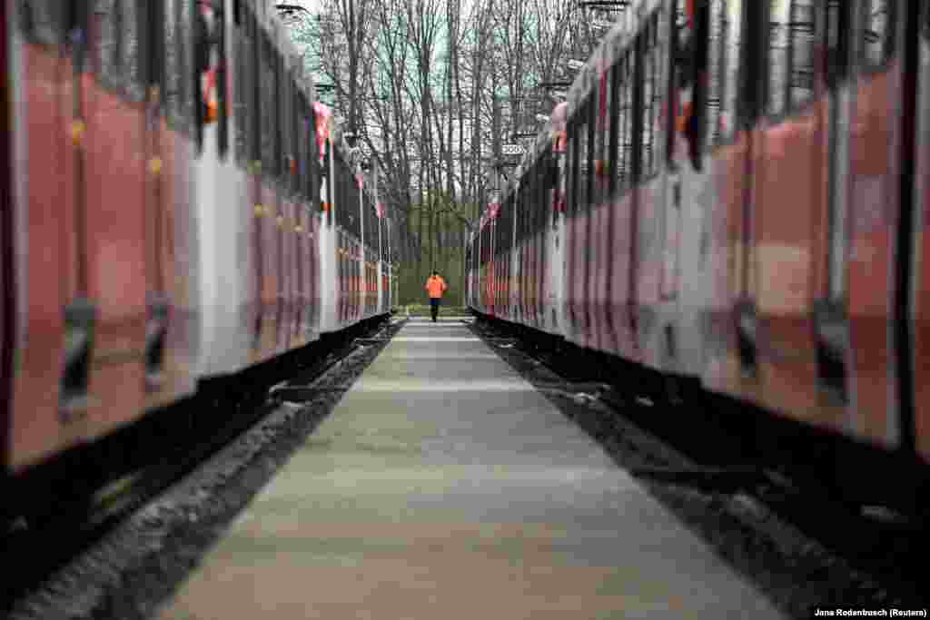 Një shofer tramvaji ecën përgjatë tramvajeve të parkuar në Bon të Gjermanisë, pasi punëtorët e këtij sektori hyn në grevë më 27 mars 2023.