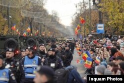 Un cordon de forțe de ordine se află între vehiculele militare și civili la parada organizată în acest an de Ziua Națională a României.