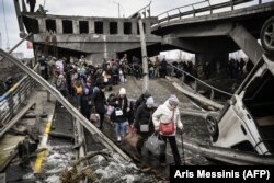 Люди переходят разрушенный мост, эвакуируясь из Ирпеня. 5 марта 2022 года