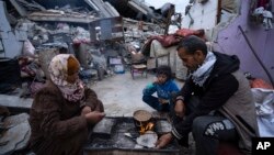 Palestinska porodica ispred svog uništenog doma u izraelskim vazdušnim napadima u Rafi, Pojas Gaze, ponedeljak, 18. mart 2024.