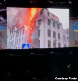 Снимок горящего здания в Харькове, который музыканты Prime Orchestra демонстрируют зрителям на концертах