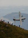 Pasionații de fotografie aeriană și turiștii care erau pe Vârful Caraiman (2.384 metri) au fost surprinși pe 10 iulie cu un eveniment organizat în premieră în România:&nbsp;&bdquo;Spotter day&rdquo;.<br />
<br />
Avioane și elicoptere militare au survolat Munții Bucegi cu&nbsp;ocazia Zilei Aviaţiei Române şi a Forţelor Aeriene, sărbătorită în fiecare an pe 20 iulie.<br />
<br />
În imagine: o aeronavă de transport C-27J Spartan.