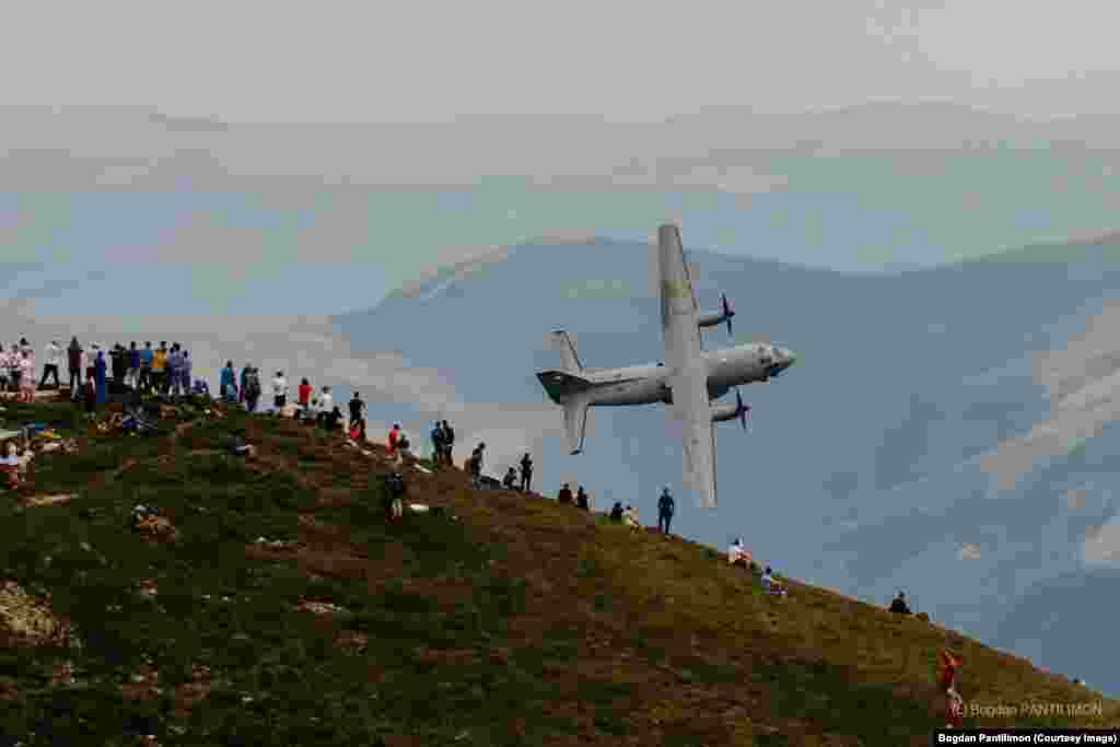 Pasionații de fotografie aeriană și turiștii care erau pe Vârful Caraiman (2.384 metri) au fost surprinși pe 10 iulie cu un eveniment organizat în premieră în România:&nbsp;&bdquo;Spotter day&rdquo;. Avioane și elicoptere militare au survolat Munții Bucegi cu&nbsp;ocazia Zilei Aviaţiei Române şi a Forţelor Aeriene, sărbătorită în fiecare an pe 20 iulie. În imagine: o aeronavă de transport C-27J Spartan.