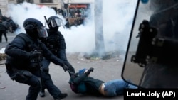 Францияда полиция жасағы зейнет реформасына қарсылық шеруі кезінде демонстрантты ұстап жатыр. 2023 жылғы қаңтар.