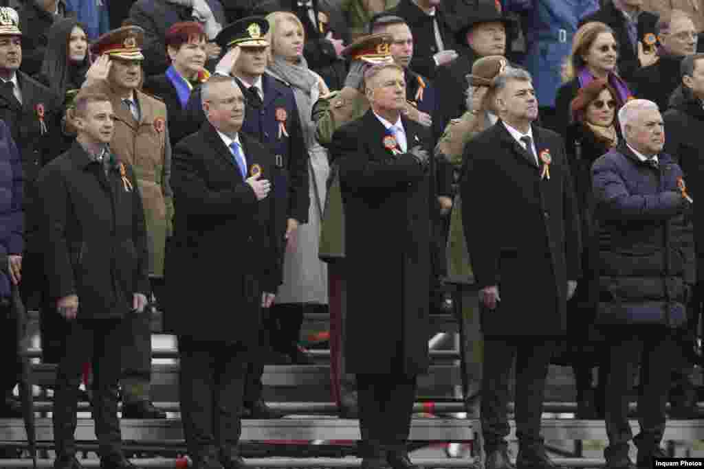 La parada militară din Capitală au asistat preşedintele Klaus Iohannis, premierul Marcel Ciolacu, preşedintele Senatului, Nicolae Ciucă, preşedintele interimar al Camerei Deputaţilor, Alfred Simonis, membri ai Guvernului, şefi de instituţii, reprezentanţi ai corpului diplomatic şi ai cultelor religioase.