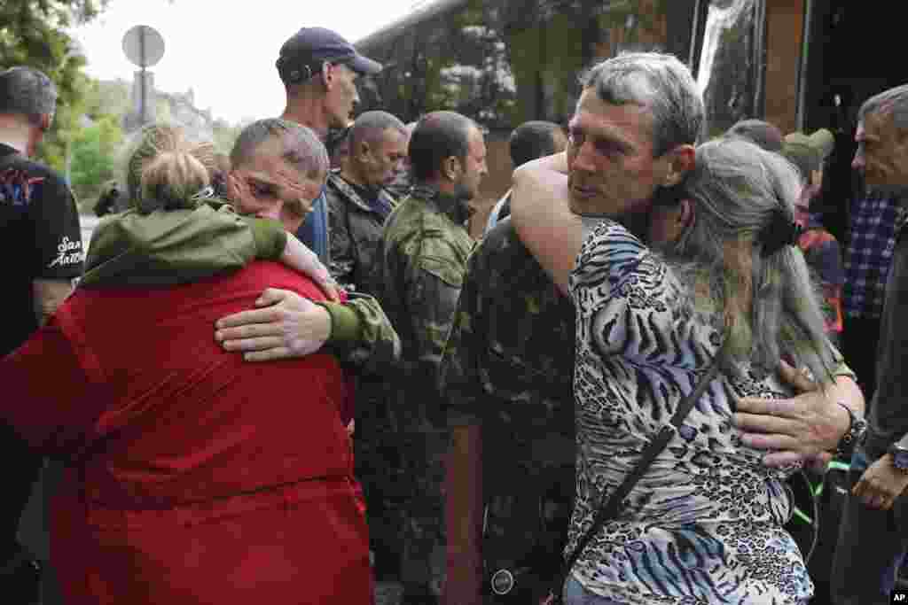 Men who signed up for contract military service embrace their loved ones before heading to assigned units in Volgograd, Russia.