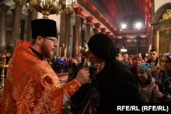 Egy pap istentiszteletet tart egy szentpétervári ortodox templomban