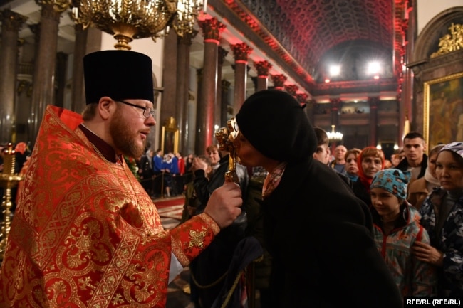 Egy pap istentiszteletet tart egy szentpétervári ortodox templomban