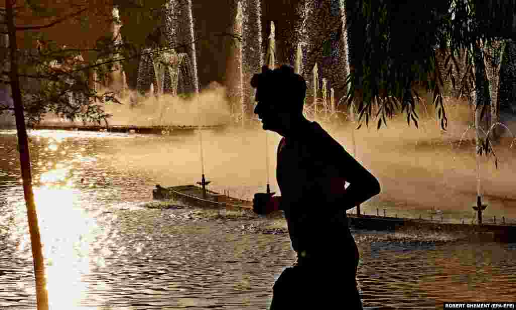 A man runs in a park in Bucharest on a hot summer day with temperatures reaching 42 degrees Celsius.