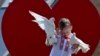A boy wearing a &quot;vyshyvanka,&quot; a traditional Ukrainian embroidered blouse, holds pigeons as he poses for his mother on Independence Square in Kyiv during Vyshyvanka Day on May 18.