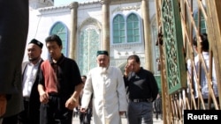 Этнические уйгуры выходят из мечети после послеобеденной молитвы в Урумчи, Синьцзян, 12 сентября 2004 года
