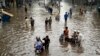 Ljudi se probijaju kroz poplavljeni put u Lahoreu, Pakistan, 26. jula.