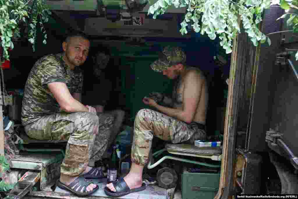 Військові чистять зброю, ховаючись від дощу в десантному відділенні M2 Bradley