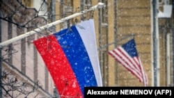 A Russian flag flies next to the U.S. Embassy building in Moscow.