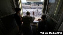 Pope Francis leads the Angelus prayer from his window at the Vatican on July 23.