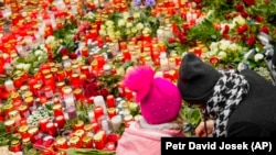Майданчик перед Карловим університетом заповнений лампадками і квітами. Люди вражені тим, що сталося. Приходять, щоб висловити співчуття родинам загиблих. Прага, 22 грудня 2023 року