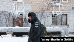 Мъж минава покрай жилищна сграда в квартал Климовск в град Подолск, останал без отопление след авария, 7 януари 2024 г.