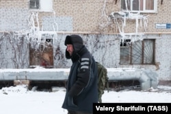 A man walks past an apartment block in the Klimovsk neighborhood of Podolsk that was left without heating and hot water due to burst pipes.