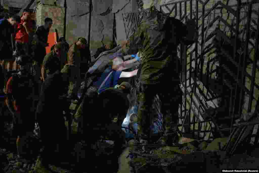 Volunteers help to free a person from debris at the site of the shattered building.