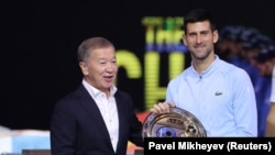 Президент федерации тенниса Казахстана Булат Утемуратов вручает награду сербскому теннисисту Новаку Джоковичу после турнира в Астане. Октябрь 2022 года