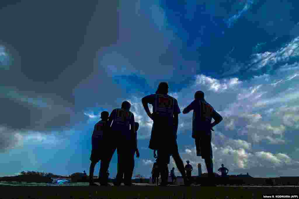 Ground staff cover the pitch as rain stops play during a cricket game between Sri Lanka and Pakistan in the city of Galle, Sri Lanka, on July 17.&nbsp;