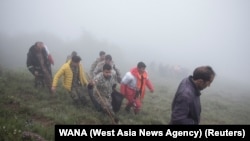 Rescuers recover bodies at the site where a helicopter carrying Iranian President Ebrahim Raisi crashed in a fog-shrouded mountainous area of northwest Iran on May 20.<br />
<br />
Raisi, 63, and his companions, including Foreign Minister Hossein Amir-Abdollahian, have been found dead at the site of the crash.&nbsp;&nbsp;
