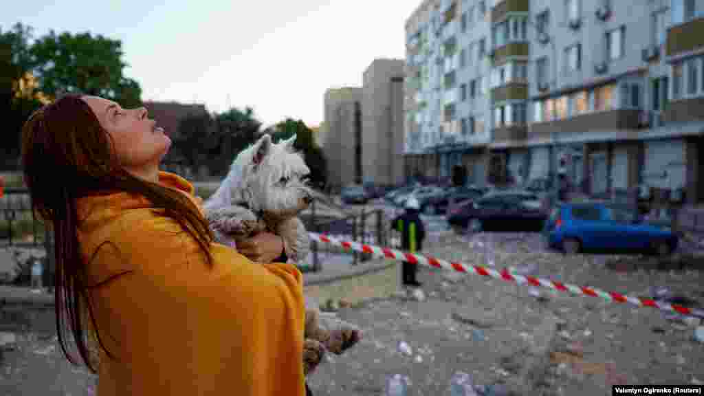 Egy nő és kutyája a hajnali dróncsapásban megsérült házuknál. Az ukrán hadsereg szerint a támadást kizárólag iráni gyártmányú drónokkal követték el, és éjféltől hajnali fél ötig tartott